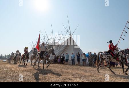 Nez Perce Reiter in einer Prozession um ein Langhaus in am'saaxpa, Wallowa Valley, Oregon. Stockfoto