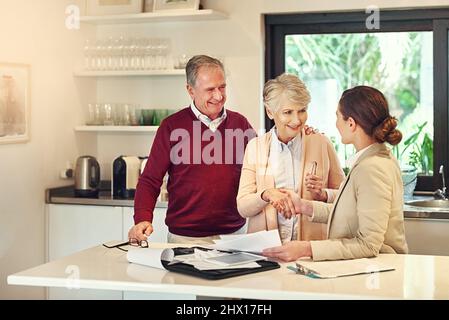 Wir wussten, dass Geld für unsere Pensionspläne wichtig sein würde. Aufnahme eines älteren Paares, das von seinem Finanzberater beraten wurde. Stockfoto