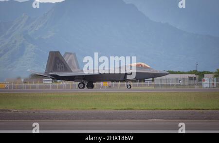 Ein F-22 Raptor-Flugzeug der US Air Force aus den 19. Fighter Squadron-Taxis der Marine Corps Air Station Kanehoe Bay, Hawaii während einer Trainingsübung. Die F-22s wurden mit Kraftstoff beladen, der von einem C-130 Hercules-Flugzeug der Nevada Air National Guard abgeladen wurde. (USA Foto der Air National Guard von Thomas Cox, dem Senior Airman) Stockfoto