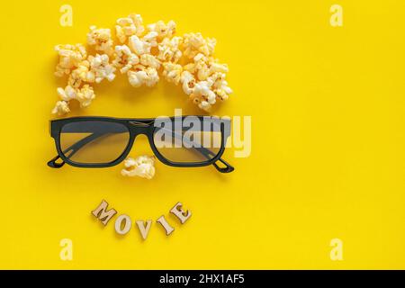 Abstraktes Bild des Betrachters, 3D Gläser und Popcorn, TEXTFILM auf gelbem Hintergrund. Stillleben, Draufsicht, flaches Lay. Konzept Kino und Unterhaltung Stockfoto