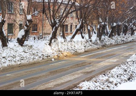 Schmutziger Schnee auf den Straßen der Stadt in Sibirien. Sand und Reagenzien gegen Eisglätte. Stockfoto