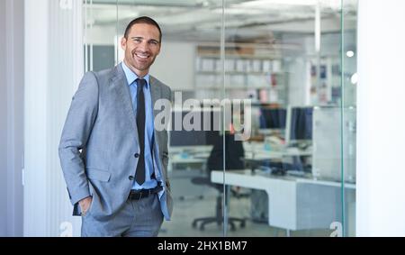 HES ist ein Schwergewicht des Unternehmens. Aufnahme eines gutaussehenden Geschäftsmannes, der in seinem Büro steht. Stockfoto