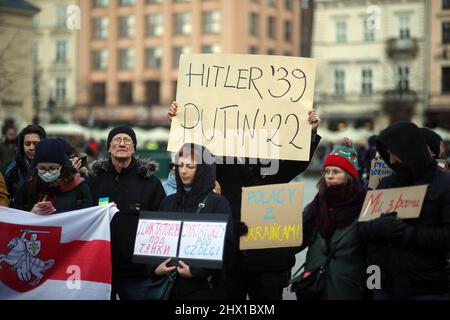 Krakau, Polen. 27.. Februar 2022. Ein Protestler hält während der Demonstration ein Plakat mit der Aufschrift "Hitler '39 Putin '22'" mitten in der Menge hoch.nach der russischen Aggression auf die Ukraine im Februar dieses Jahres protestieren Menschen auf der ganzen Welt, um Unterstützung für das angegriffene Land zu zeigen. Eine von ihnen war eine von den in Krakau lebenden Weißrussen organisierte Demonstration, die die Freiheit der Ukraine und Weißrussland forderte. (Bild: © Vito Corleone/SOPA Images via ZUMA Press Wire) Stockfoto
