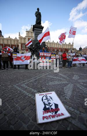 Krakau, Polen. 27.. Februar 2022. Eine Illustration eines Putin-Hitler-Hybryds, der "zwei Gesichter - ein Monster" unterzeichnete, mit Demonstranten, die sich während der Demonstration im Hintergrund versammelten.nach der russischen Aggression auf die Ukraine im Februar dieses Jahres protestierten Menschen auf der ganzen Welt, um Unterstützung für das angegriffene Land zu zeigen. Eine von ihnen war eine von den in Krakau lebenden Weißrussen organisierte Demonstration, die die Freiheit der Ukraine und Weißrussland forderte. (Bild: © Vito Corleone/SOPA Images via ZUMA Press Wire) Stockfoto