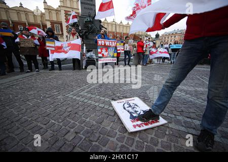 Krakau, Polen. 27.. Februar 2022. Ein Protestler trampelt während der Demonstration eine Illustration der Halb-Putin-, Half-Hitler-Karikatur.nach der russischen Aggression auf die Ukraine im Februar dieses Jahres protestieren Menschen auf der ganzen Welt, um Unterstützung für das angegriffene Land zu zeigen. Eine von ihnen war eine von den in Krakau lebenden Weißrussen organisierte Demonstration, die die Freiheit der Ukraine und Weißrussland forderte. (Bild: © Vito Corleone/SOPA Images via ZUMA Press Wire) Stockfoto
