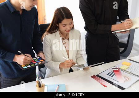 Eine Gruppe kreativer Innenarchitekten arbeitet zusammen und diskutiert die Innenarchitektur für ihr Projekt. Meeting-Konzept. Stockfoto