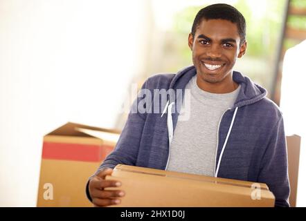 HES Umzug. Ein hübscher junger Mann, der Kisten verpackt. Stockfoto