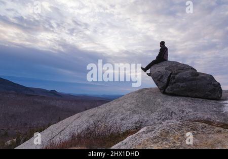 Bewölkter Sonnenuntergang von Mitte Sugarloaf Mountain in Bethlehem, New Hampshire während der Wintermonate. Stockfoto