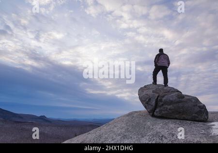 Bewölkter Sonnenuntergang von Mitte Sugarloaf Mountain in Bethlehem, New Hampshire während der Wintermonate. Stockfoto