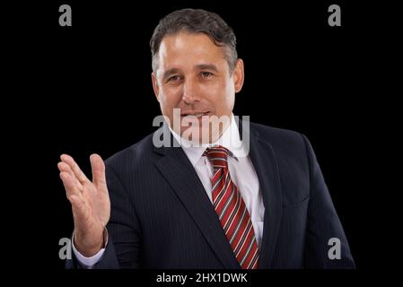 Er hat feste Überzeugungen. Ein ernsthafter Mann im Anzug, der beim Sprechen mit der Hand gestikuliert. Stockfoto