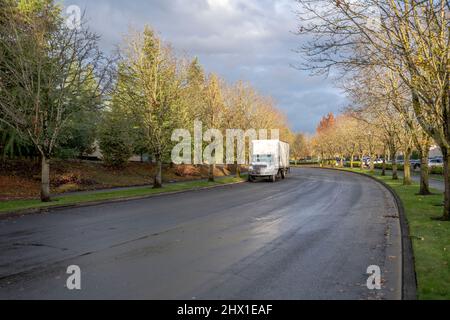 Weißer kompakter industrieller Mittelkraft-Tagestab-Rig-Sattelschlepper mit Boxanhänger für lokale Frachten, die auf der Stadtstraße in der Industrie stehen Stockfoto