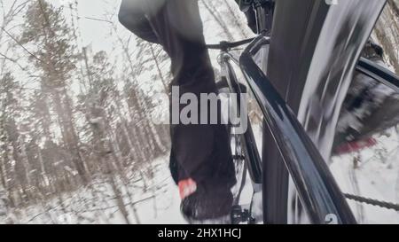 Action Cam am dahinter installierten Rahmen. Nahaufnahme der Pov-Ansicht. Professioneller Extremsportler Biker, der im Winterschneehaus im Freien fette Bikes fährt. Stockfoto