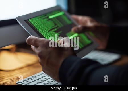 Kein System ist nicht stapelbar. Ausgeschnittene Aufnahme eines nicht identifizierbaren Hackers, der im Dunkeln einen Computercode knackt. Stockfoto