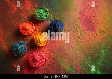 Glücklicher Holi-Hintergrund. Bio-Farbpulver in Schale für Holi-Festival. Stockfoto