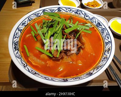 Jjamppong, koreanische Nudelsuppe mit roter, würziger, auf Meeresfrüchten basierender Brühe, gewürzt mit Chilipulver. Chinesisches Essen im koreanischen Stil. Stockfoto