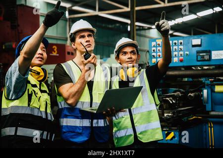 Porträt eines erfolgreichen kaukasischen Ingenieurs-Managers mittleren Alters mit weißem Helm, der die Funkkommunikation hält, um den Arbeiter zu kontrollieren und das Geschäft einzuchecken Stockfoto