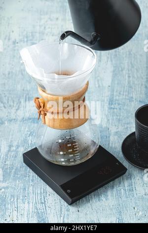 Der professionelle Barista bereitet Kaffee nach dem Gießverfahren zu. Alternative Möglichkeiten zum Brühen von Kaffee. Café-Konzept. Stockfoto