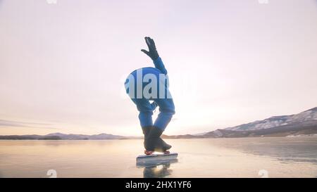 Das Mädchen trainiert auf Eisschnelllauf. Das Kind Schlittschuhe im Winter in blauem Sportswear-Anzug, Sportbrille. Kinder Eisschnelllauf Sport. Zeitlupe im Freien. Schneebedeckte Berge, schönes Eis. Stockfoto