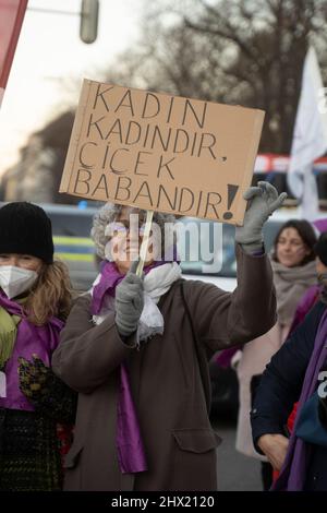Lächelnder Teilnehmer mit Schild. Am 8. März 2022 versammelten sich Hunderte von Teilnehmern am Internationalen Frauentag am Königsplatz in München zu einem feministischen Streik. (Foto von Alexander Pohl/Sipa USA) Stockfoto