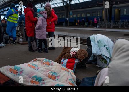 Spanien. 07. März 2022. Flüchtlinge mit Gepäck und Koffern werden auf einem Bahnsteig am Bahnhof Lviv-Holovnyi gesehen, der darauf wartet, am 7. März 2022 in einen Zug zu steigen, um aus dem Land nach Lviv, Ukraine, zu fliehen. Als westlichste Stadt der Ukraine ist Lviv zu einer wichtigen Anlaufstelle für Flüchtlinge aus dem ganzen Land geworden, die aus dem Krieg fliehen und dann in Züge in andere Länder Europas wie Polen oder Ungarn fahren. Mehr als 2 Millionen Menschen, vor allem Frauen und Kinder, haben das Land bereits verlassen. (Foto von Davide Bonaldo/Sipa USA) Quelle: SIPA USA/Alamy Live News Stockfoto