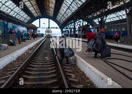 Spanien. 07. März 2022. Flüchtlinge mit Gepäck und Koffern laufen auf einer Plattform am Bahnhof Lviv-Holovnyi, die darauf wartet, am 7. März 2022 in einen Zug zu steigen, um aus dem Land nach Lviv, Ukraine, zu fliehen. Als westlichste Stadt der Ukraine ist Lviv zu einer wichtigen Anlaufstelle für Flüchtlinge aus dem ganzen Land geworden, die aus dem Krieg fliehen und dann in Züge in andere Länder Europas wie Polen oder Ungarn fahren. Mehr als 2 Millionen Menschen, vor allem Frauen und Kinder, haben das Land bereits verlassen. (Foto von Davide Bonaldo/Sipa USA) Quelle: SIPA USA/Alamy Live News Stockfoto