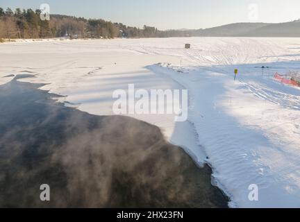 Winternebel über Squam Lake in Ashland, New Hampshire während der Wintermonate. Stockfoto