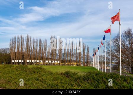 Masten mit Flaggen Polens und der Europäischen Union. Inschrift: Nigdy wiecej wojny (auf Englisch: No more war) im Hintergrund. Danzig Westerplatte, Polen Stockfoto