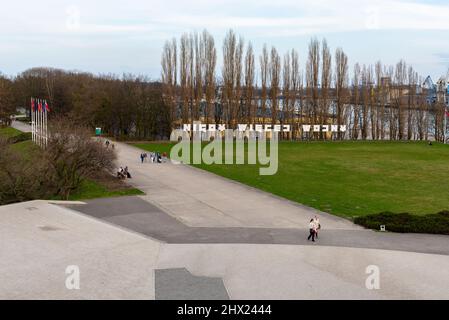 Danzig, Polen - 15. April 2017: Menschen besuchen Westerplatte. Die Inschrift - Nigdy wiecej wojny (auf englisch: No more war) im Hintergrund. Stockfoto