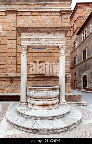 Alter weißer Marmorbrunnen (Piccolomini-Brunnen) auf der Piazza Pio II in Pienza. Toskana, Italien Stockfoto