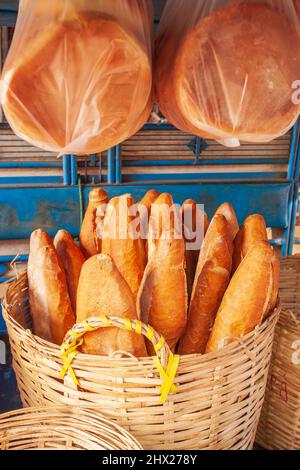 Baguette oder französisches Brot in den Korbkörben, die auf einem lokalen Markt in Pakse, Laos, verkauft werden. Laotischer Stil. Stockfoto