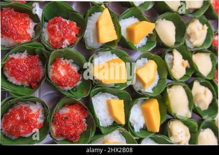 Süße reife Mango und klebriger Reis in Kokosmilch in Bananenblättern, thailändisches Süßfleisch, thailändisches Dessert. Draufsicht. Nahaufnahme. Stockfoto