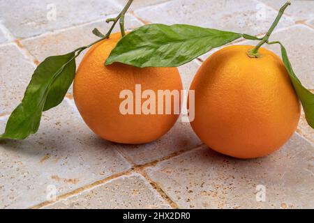 Mandarine mit isolierten Blättern auf einem Tisch Stockfoto