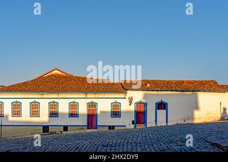 Fassade des alten Hauses im Kolonialstil Architektur in der Stadt Ouro Preto, Minas Gerais mit blauen Fenstern und Tür und den Himmel im Hintergrund.