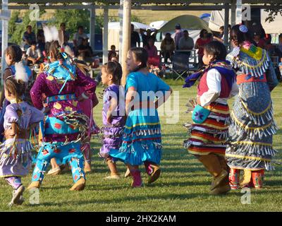 Junge indianische Tänze, die an dem Pow Wow Festival in Kostümen teilnehmen. Stockfoto