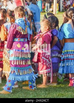 Junge indianische Tänze, die an dem Pow Wow Festival in Kostümen teilnehmen. Stockfoto