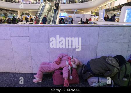 Zwei Kinder sahen auf der Flucht vor der aktuellen Kriegskrise in der Ukraine auf ihrem Gepäck im Bahnhof Warszawa Centralna schlafen. Während die Kriegskrise in der Ukraine anhält, sind Millionen Ukrainer aus ihrer Heimat nach Polen geflohen, die meisten davon sind Frauen und Kinder. Die meisten von ihnen ruhen vorübergehend auf Bahnhöfen in Warschau und warten auf ihre Abseilung. Nach Angaben der UN-Agentur hat die Zahl der Flüchtlingsmigration 1,5 Millionen erreicht, was die schnellste seit dem Zweiten Weltkrieg ist. Die polnische Regierung hat einen Plan von 8 Milliarden Zloty ($1,7 Milliarden) zur Unterstützung der Flüchtlinge angekündigt. Stockfoto