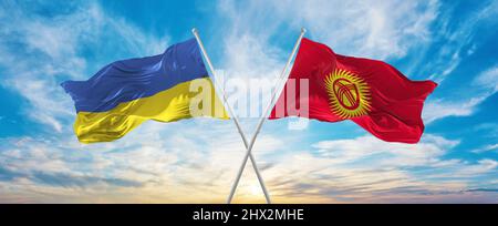 Gekreuzte Nationalflaggen der Ukraine und Kirgisistans, die bei bewölktem Himmel im Wind winken. Symbolisiert Beziehung, Dialog, Reisen zwischen zwei Ländern Stockfoto