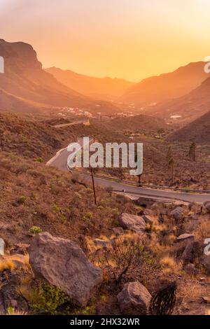 Blick auf die Straße durch die Berglandschaft während der goldenen Stunde in der Nähe von Tasarte, Gran Canaria, Kanarische Inseln, Spanien, Europa Stockfoto