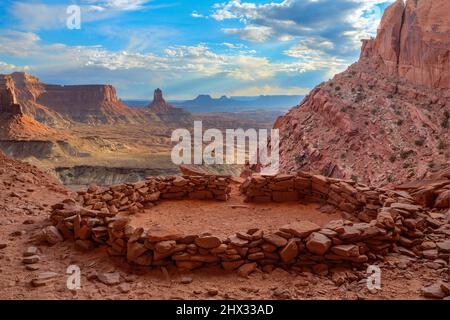 Die False Kiva Ruine in einer Nische im Canyonlands National Park in der Nähe von Moab, Utah. In der Ferne befindet sich der Candlestick Tower, ein Sandstein-Monolith von Wing Stockfoto