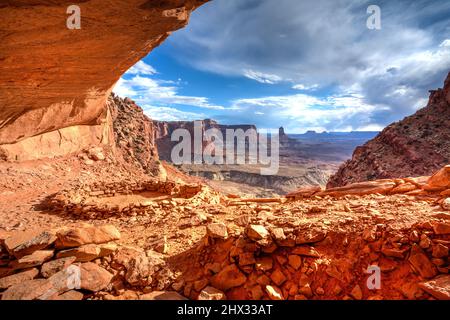 Die False Kiva Ruine in einer Nische im Canyonlands National Park in der Nähe von Moab, Utah. In der Ferne befindet sich der Candlestick Tower, ein Sandstein-Monolith von Wing Stockfoto