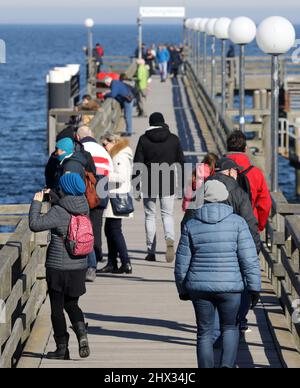 09. März 2022, Mecklenburg-Vorpommern, Kühlungsborn: Wanderer auf der Seebrücke genießen das sonnige Wetter. Foto: Bernd Wüstneck/dpa-Zentralbild/ZB Stockfoto