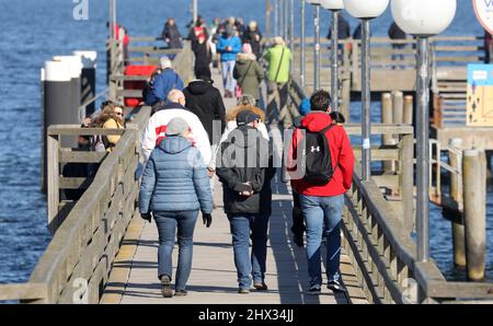 09. März 2022, Mecklenburg-Vorpommern, Kühlungsborn: Wanderer auf der Seebrücke genießen das sonnige Wetter. Foto: Bernd Wüstneck/dpa-Zentralbild/ZB Stockfoto