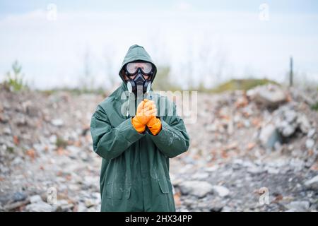 Ein Mann in Schutzmaske und Schutzkleidung erkundet die Gefahrenzone. Ökologische Katastrophe. Selektiver Fokus Stockfoto