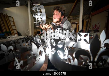 Lewis Wilde inspiziert den Kronenabschnitt eines der gasbetriebenen Leuchttürme, die er hergestellt hat und mit denen der Beginn des Platin-Jubiläums von Königin Elizabeth II. Im Juni auf der Fountain Designs-Werkstatt in Selkirk, in den Scottish Borders, signalisiert werden soll. Inspiriert von den Kronjuwelen, die bei der Krönung 1953 verwendet wurden, werden die Leuchttürme zu den Tausenden gehören, die von Gemeinden, Wohltätigkeitsorganisationen und anderen Gruppen im ganzen Land und in den überseeischen Gebieten beim ersten Gemeinschaftsereignis des viertägigen Jubiläumswochenendes im Juni beleuchtet werden. Bilddatum: Mittwoch, 9. März 2022. Stockfoto