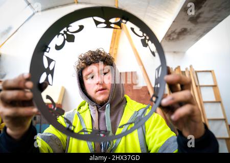 Lewis Wilde inspiziert den Kronenabschnitt eines der gasbetriebenen Leuchttürme, die er hergestellt hat und mit denen der Beginn des Platin-Jubiläums von Königin Elizabeth II. Im Juni auf der Fountain Designs-Werkstatt in Selkirk, in den Scottish Borders, signalisiert werden soll. Inspiriert von den Kronjuwelen, die bei der Krönung 1953 verwendet wurden, werden die Leuchttürme zu den Tausenden gehören, die von Gemeinden, Wohltätigkeitsorganisationen und anderen Gruppen im ganzen Land und in den überseeischen Gebieten beim ersten Gemeinschaftsereignis des viertägigen Jubiläumswochenendes im Juni beleuchtet werden. Bilddatum: Mittwoch, 9. März 2022. Stockfoto