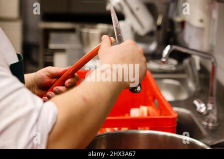 Flensburg, Deutschland. 09. März 2022. Ein Mann arbeitet in der Küche des Restaurants 'das Grace'. Das Restaurant Flensburg hat sich mit seiner Küche einen Stern verdient und ist nun im Michelin-Führer dafür gelistet. Am 9. März 2022 wurden die besten Restaurants in Deutschland ausgewählt. Insgesamt listet der Guide Michelin 2022 327 Gourmet-Restaurants in Deutschland auf – darunter neun drei-Sterne-Restaurants und 46 zwei-Sterne-Restaurants. Der Restaurantführer des Reifenherstellers geht am 14. März in den Handel. Quelle: Frank Molter/dpa/Alamy Live News Stockfoto
