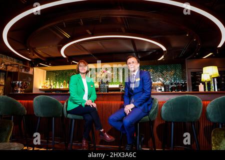 Flensburg, Deutschland. 09. März 2022. Christina (l.) und Bernd Storch, Betreiber des Hotel James, sitzen an der Bar des hoteleigenen Restaurants das Grace. Das Restaurant Flensburg hat sich mit seiner Küche einen Stern verdient und ist nun im Michelin-Führer dafür gelistet. Am 9. März 2022 wurden die besten Restaurants in Deutschland ausgewählt. Insgesamt listet der Guide Michelin 2022 327 Gourmet-Restaurants in Deutschland auf – darunter neun drei-Sterne-Restaurants und 46 zwei-Sterne-Restaurants. Der Restaurantführer des Reifenherstellers geht am 14. März in den Handel. Quelle: Frank Molter/dpa/Alamy Live News Stockfoto