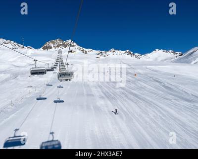 Eine Fahrt im Sessellift über weiße Pisten im verlassenen Skigebiet Stockfoto