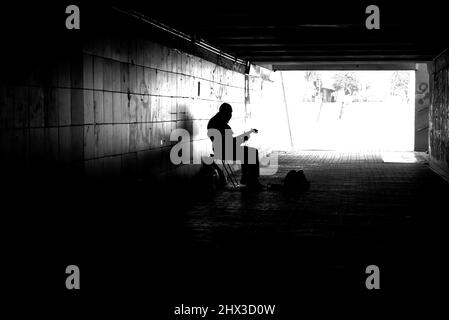 Straßenmusiker mit Gitarre in der Unterführung. Stockfoto