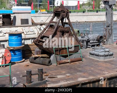 Nahaufnahme eines alten rostigen Zweischalengreifer von Drahtseilen und Ketten. Stockfoto